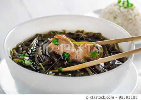 Korean seaweed soup with meat in white bowl and boiled rice. Birthday soup. Traditional Korean Cuisine. Healthy diet. Pregnancy. Custom. Close up. Korean seaweed soup with meat in white bowl and boiled rice. Birthday soup. Traditional Korean Cuisine. Healthy diet. Pregnancy. Custom. Close up. 98393183