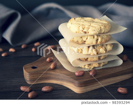Pile of peanut cookies on a wooden board, dark rustic background 98393294