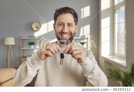 Portrait of happy, joyful, excited man holding key to his new house or apartment 98393312