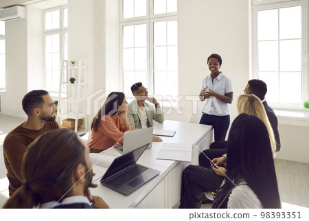 Smiling African American businesswoman lead meeting with colleagues Smiling African American businesswoman lead meeting with colleagues 98393351