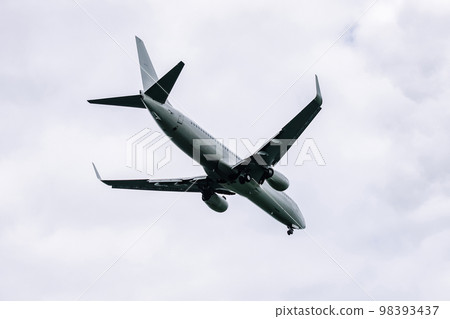Passenger plane comes in for landing in cloudy weather. Passenger plane comes in for landing in cloudy weather. 98393437