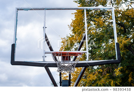 Broken glass backboard and broken hoop on the basketball court 98393438