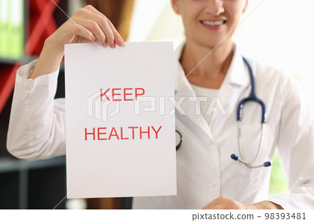 Paper with words keep healthy close up and female doctor with stethoscope in background. Paper with words keep healthy close up and female doctor with stethoscope in background. 98393481