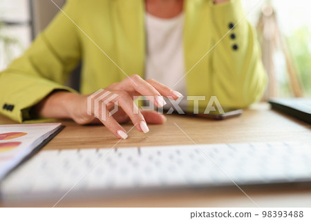 Business woman sits at her office desk with computer and smartphone and thinks about business projects. 98393488