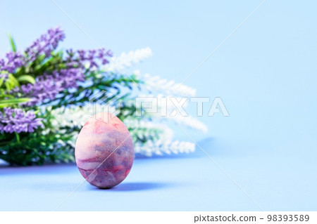 Purple and lilac with blue Easter egg on a blue background with a place for text. Happy Easter concept. Greeting card. Purple and lilac with blue Easter egg on a blue background with a place for text. Happy Easter concept. Greeting card. 98393589