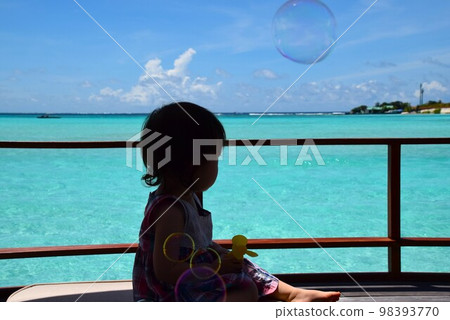 Child playing with soap bubbles in a water cottage in the Maldives Child playing with soap bubbles in a water cottage in the Maldives 98393770