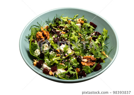 Salad with beets rucola parsley herbs feta cheese walnuts in a bowl on isolated background. Salad with beets rucola parsley herbs feta cheese walnuts in a bowl on isolated background. 98393837