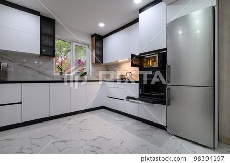 A luxurious, modern kitchen with a white color palette 98394197