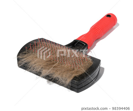 Plastic brush and combing out wool in animals and a tuft of gray cat hair on a white background 98394406