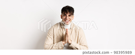 Handsome caucasian man say thank you, bowing with namaste gesture, looking grateful and smiling at camera, standing on white background Handsome caucasian man say thank you, bowing with namaste gesture, looking grateful and smiling at camera, standing on white background 98395989