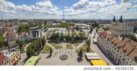The center of Ivano Frankivsk city, Ukraine. Old architecture buildings with red roof tops in summer sunlight. 98396336