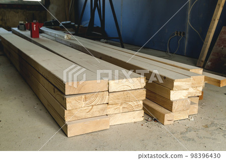 Stack of new wooden studs at the lumber yard. Wood timber construction material. Shallow depth of field effect 98396430