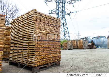 Stack of new wooden boards and studs at the lumber yard. Wooden plates on piles for furniture materials Stack of new wooden boards and studs at the lumber yard. Wooden plates on piles for furniture materials 98396433