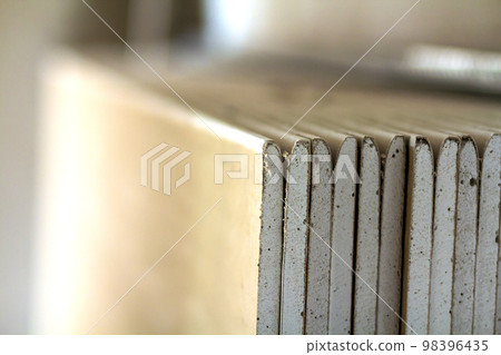 Stack of drywall plates leaning against a wall Stack of drywall plates leaning against a wall 98396435