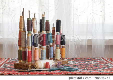 Sewing multicolored threads of soft pastel vintage colors on spools. Sewing tailor related accessories. Sewing multicolored threads of soft pastel vintage colors on spools. Sewing tailor related accessories. 98396737