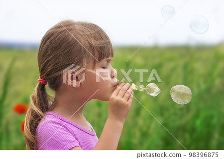 Portrait of cute lovely little girl blowing soap bubbles 98396875