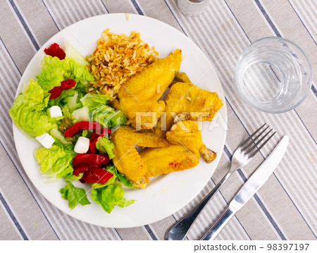 Appetizing chicken wings with rice and a vegetable salad 98397197