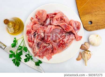 Chopped rabbit with garlic and spices on white plate with knife Chopped rabbit with garlic and spices on white plate with knife 98397273