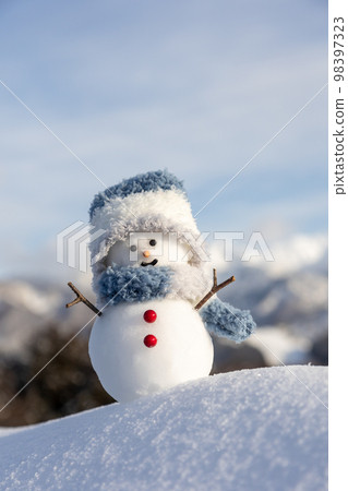 Snowman and sunny winter mountain range Snowman and sunny winter mountain range 98397323