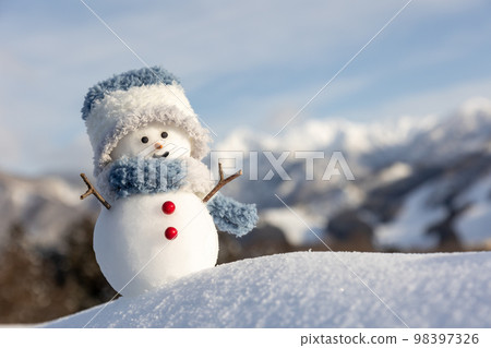 Snowman and sunny winter mountain range 98397326