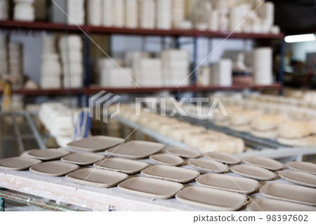 Abundance of crafted plates on shelf in ceramic workshop Abundance of crafted plates on shelf in ceramic workshop 98397602