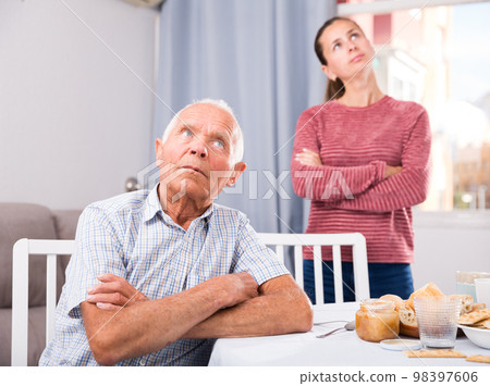 Portrait of upset senior man after quarrel with daughter at home Portrait of upset senior man after quarrel with daughter at home 98397606