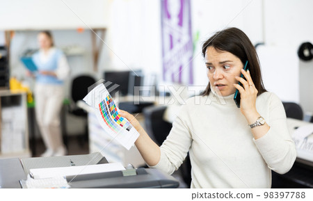 Confused woman printing office manager having telephone conversation 98397788