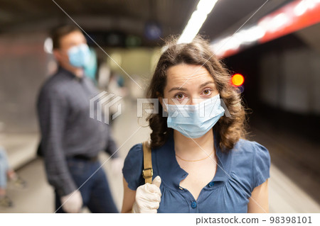 Woman in medical mask waiting for subway train Woman in medical mask waiting for subway train 98398101