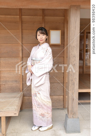 站在日本房子前的穿著和服的漂亮年輕女人 98398410