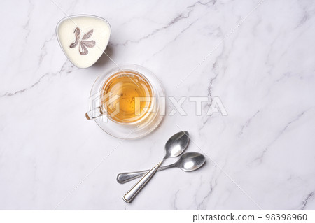 some tea and spoons on a white marble counter top with a butterfly in the image is taken from above some tea and spoons on a white marble counter top with a butterfly in the image is taken from above 98398960