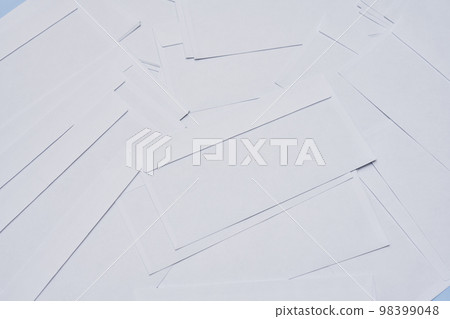 several pieces of white paper on a blue background with copy space in the top right corner, and bottom left corner 98399048