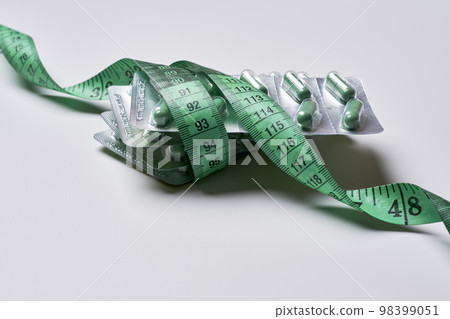 a tape wrapped around a green and white origaal shaped like an elephant, on a light grey background 98399051