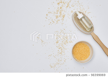 gold flakes on a white surface with a spoon full of flakes next to it and scattered flakes 98399069