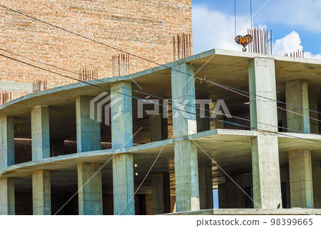 High multi-storey buildings under construction and cranes against blue sky High multi-storey buildings under construction and cranes against blue sky 98399665