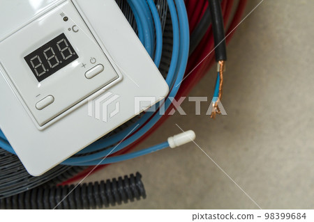 Heating floor system wires, cables and control panel. Renovation and construction concept. Comfort house. Heating floor system wires, cables and control panel. Renovation and construction concept. Comfort house. 98399684