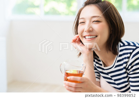 A young woman relaxing in her room Drinks A young woman relaxing in her room Drinks 98399852