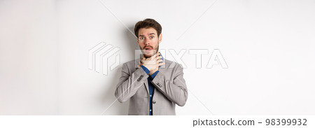 Distressed young man in business suit strangle himself and showing tongue, feeling sick with sore throat, standing on white background 98399932