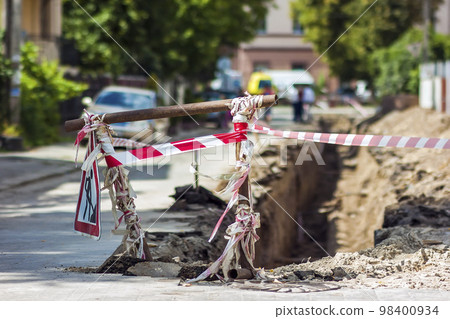Construction roadwork on street in city. Red safety sign warns about roadworks. Be careful, danger on your way 98400934