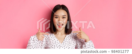 Close-up of happy and confident asian woman pointing at herself, smiling self-assured, standing over pink background 98401277