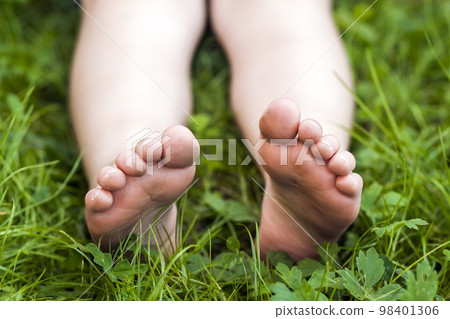 Close up of feet of little girl on green grass Close up of feet of little girl on green grass 98401306