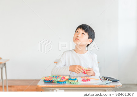 A boy in the lower grades of elementary school who learns English and English words with alphabet toys (intellectual education) A boy in the lower grades of elementary school who learns English and English words with alphabet toys (intellectual education) 98401307