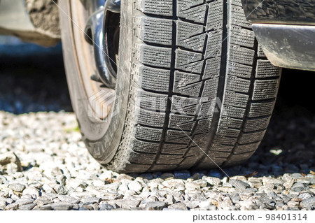 Close up of car's winter tyre tread on the gravel road Close up of car's winter tyre tread on the gravel road 98401314