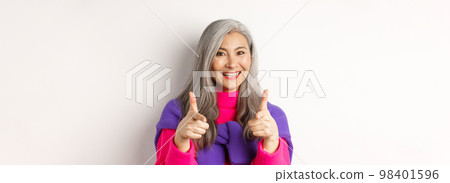 Beautiful and stylish asian grandmother pointing at camera, you can do this gesture, congratulating or praising, standing over white background Beautiful and stylish asian grandmother pointing at camera, you can do this gesture, congratulating or praising, standing over white background 98401596