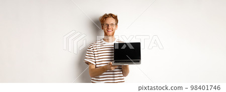 Smiling proud redhead guy showing empty laptop screen. Handsome young man demonstrating logo on computer display, white background Smiling proud redhead guy showing empty laptop screen. Handsome young man demonstrating logo on computer display, white background 98401746