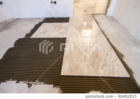Ceramic tiles. Floor tiles installation. Home improvement, renovation - ceramic tile floor adhesive, mortar Ceramic tiles. Floor tiles installation. Home improvement, renovation - ceramic tile floor adhesive, mortar 98402015