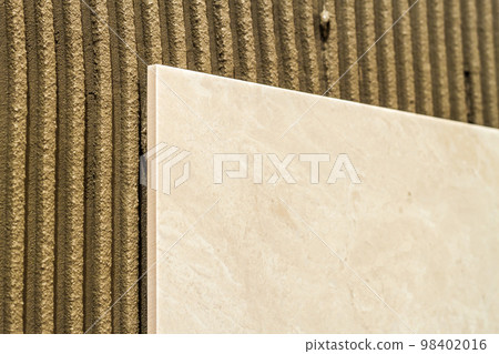 Ceramic tiles on a wall installation. Home improvement and renovation. 98402016