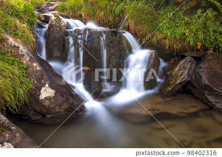 Beautiful little waterfall in mountains with white foamy water 98402316