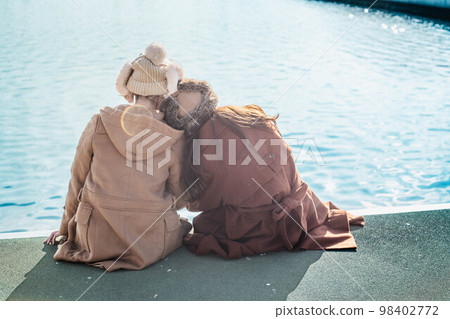 Women chatting happily at a port overlooking the sea 98402772