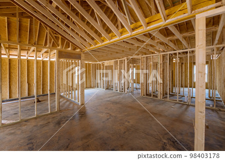 This an interior framing newly constructed house under construction, which is framed with truss beams This an interior framing newly constructed house under construction, which is framed with truss beams 98403178