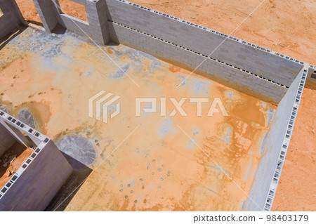 House under construction an concrete block bricks to wall for foundation on building site House under construction an concrete block bricks to wall for foundation on building site 98403179